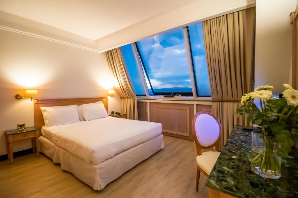 维琴察SHG德拉维尔酒店的配有一张床和花瓶的酒店客房