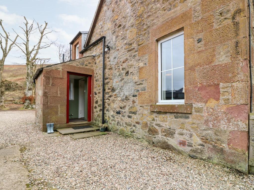 InchmillWhite Hillocks Farm House的红门和窗户的砖砌建筑