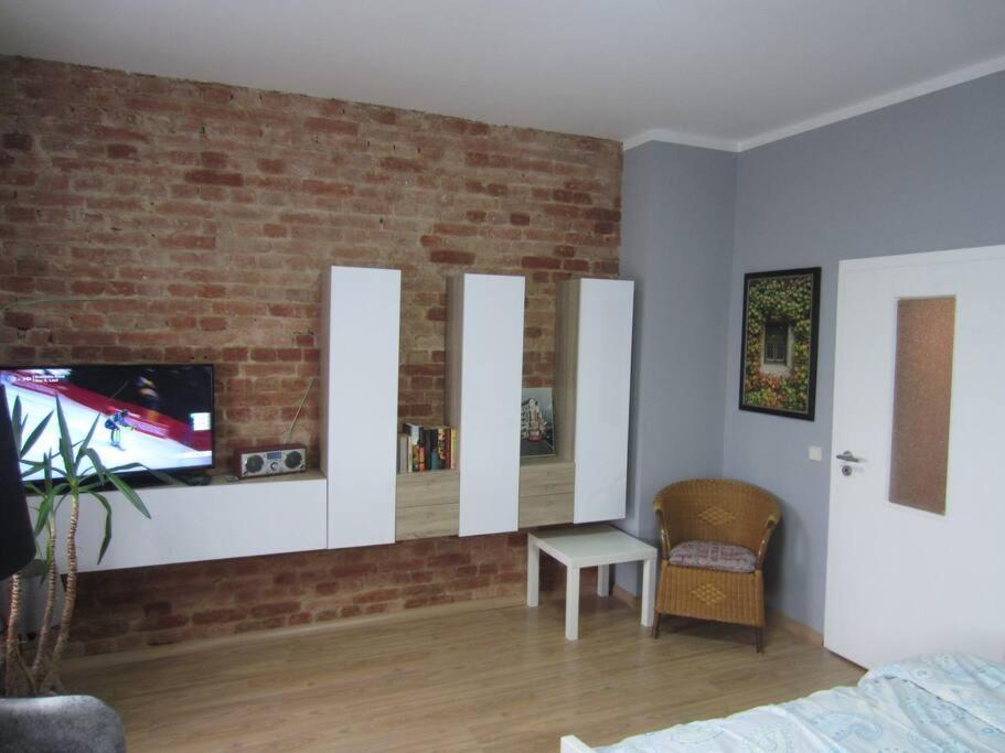 科特布斯Michas FEWO 1 nähe Zentrum的一间带电视和砖墙的卧室