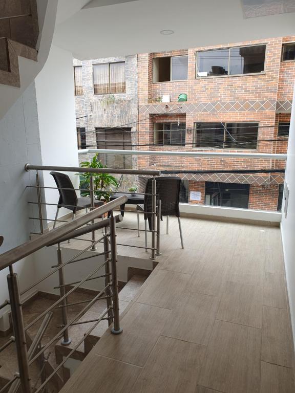基布多Acogedor ApartaStudio Zona Centro的一个带桌椅的阳台和一座建筑