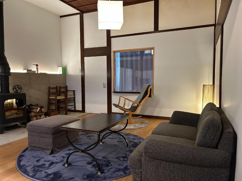 松本Satoyama villa DEN - Vacation STAY 14150的客厅配有沙发、桌子和椅子