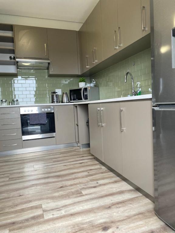 温特和克DMN City at Merensky Apartment的厨房配有不锈钢用具,铺有木地板