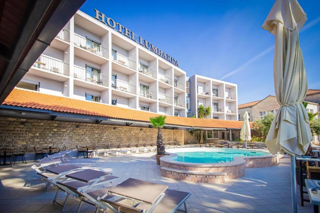 鲁巴达Hotel Lumbarda的一座带游泳池和椅子的酒店和一座建筑