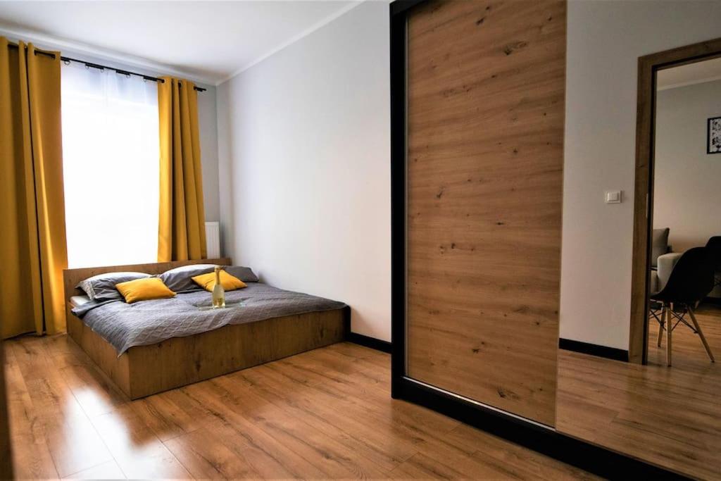 苏瓦乌基Apartament Blisko Centrum的一间卧室配有一张床和一面大镜子