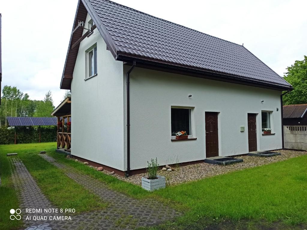 皮什Apartameny Wiktoria i Nikola w Karwiku的黑色屋顶的白色房子