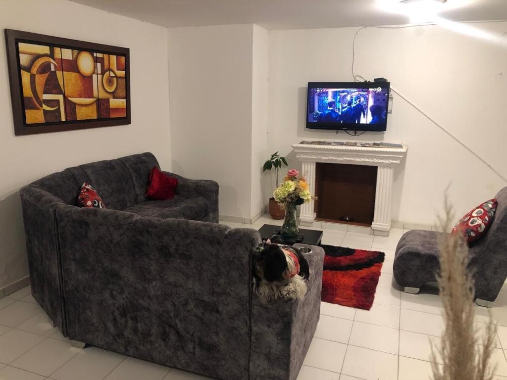波帕扬Home Travel Popayan的客厅配有两张沙发和一台电视机