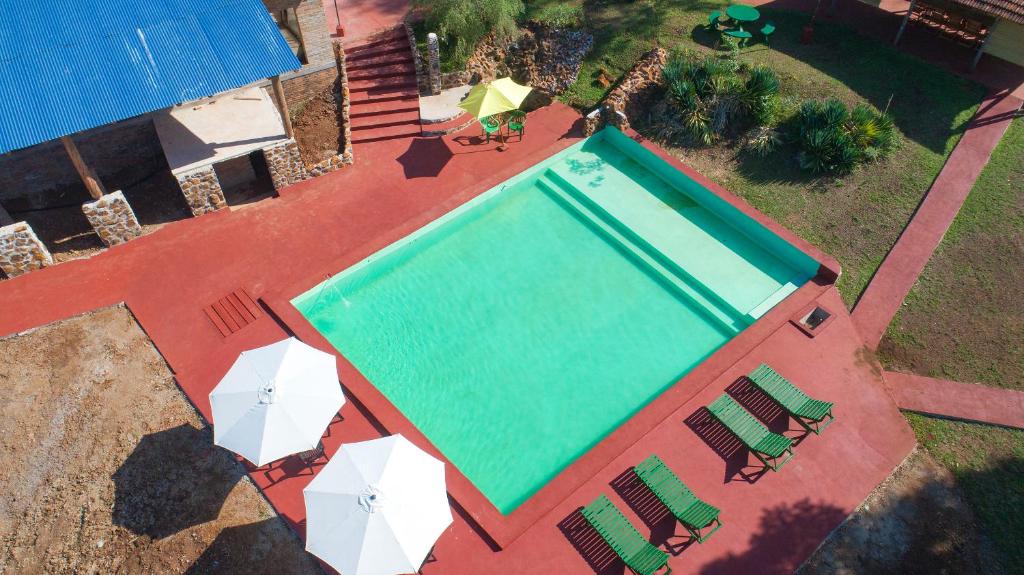 埃尔多拉多Estancia La Paulina的享有带椅子和遮阳伞的游泳池的上方景色