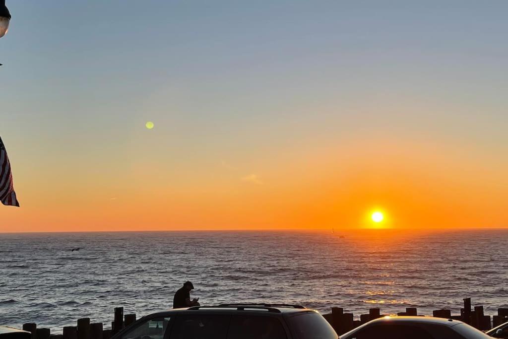 加迪纳市SouthBAY Beaches Beauty&Cozy Apt的坐在汽车顶上看日落的人