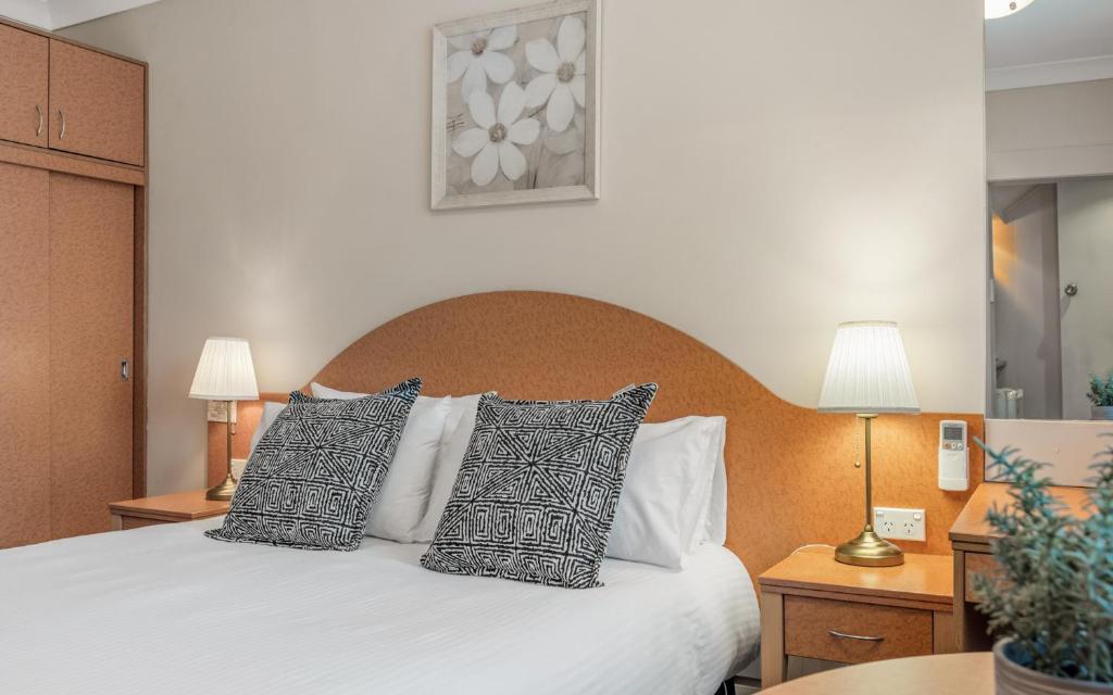 肯图巴蓝山文物汽车旅馆 的卧室配有带枕头的白色床