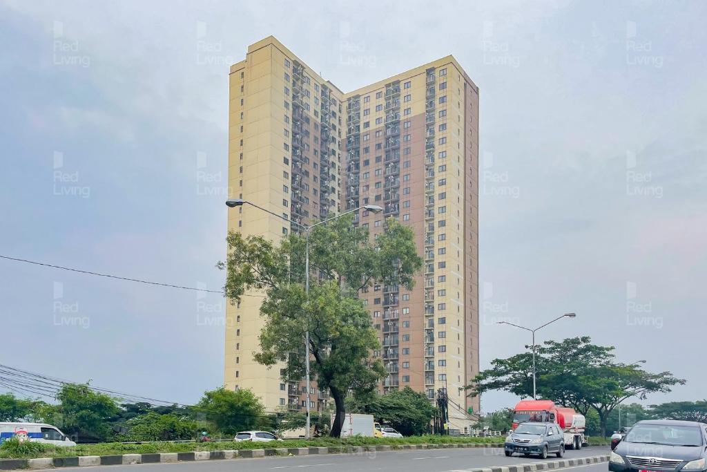 万隆RedLiving Apartemen Tamansari Panoramic - Santuy Agency Lobby P1 9的前面有一辆红色卡车的高层建筑