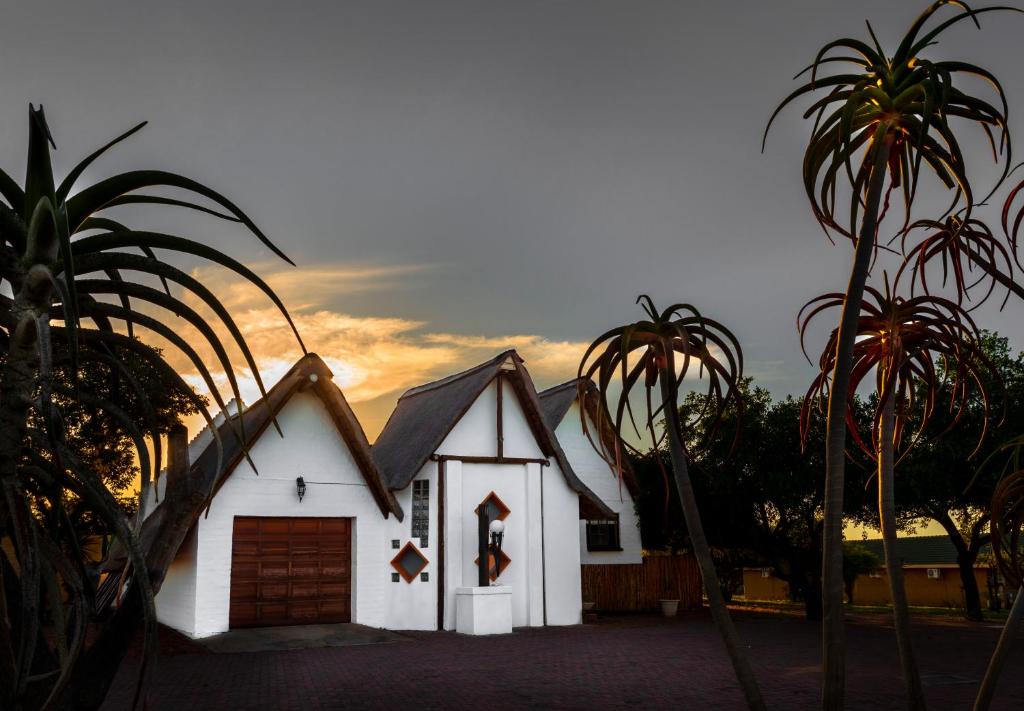 波罗瓜尼玻利维亚山林小屋的一座白色的小房子,设有车库和棕榈树