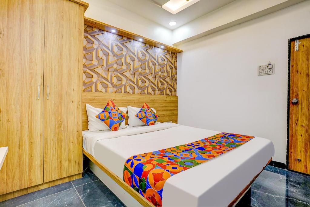 浦那FabHotel Galaxy Stay的一间卧室配有一张带彩色毯子的床