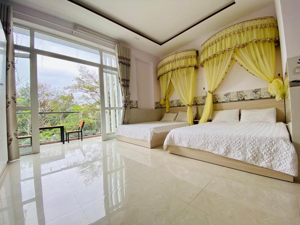 绥和市gau homestay的一间卧室设有两张床和大窗户