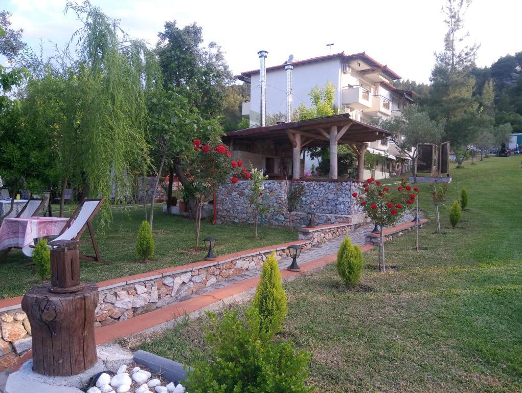 奥马斯帕纳吉亚斯Nikos Apartments的房屋前方设有长椅的花园