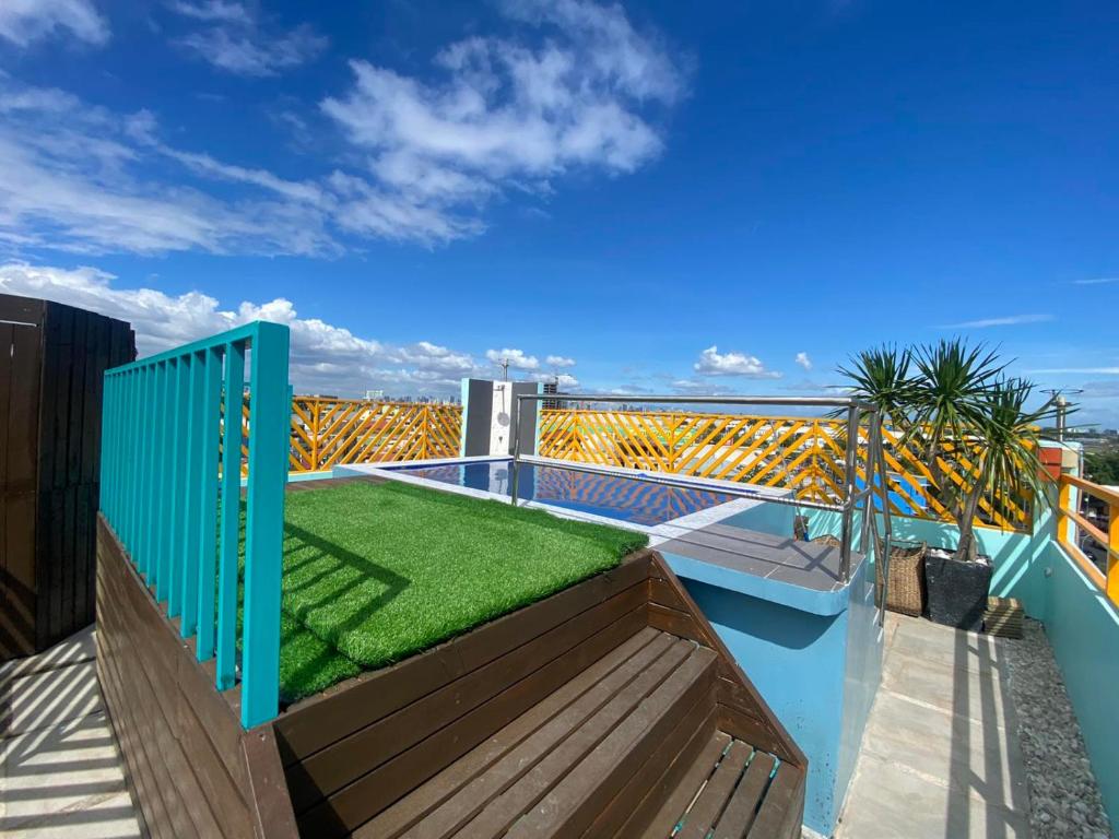 马尼拉Rain Airport Bed and Breakfast的阳台的顶部设有绿色草坪。