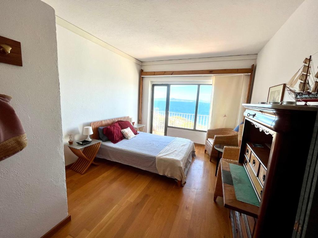 巴古尔Apartamento con playa y vistas en la Costa Brava的一间卧室设有一张床和一个大窗户