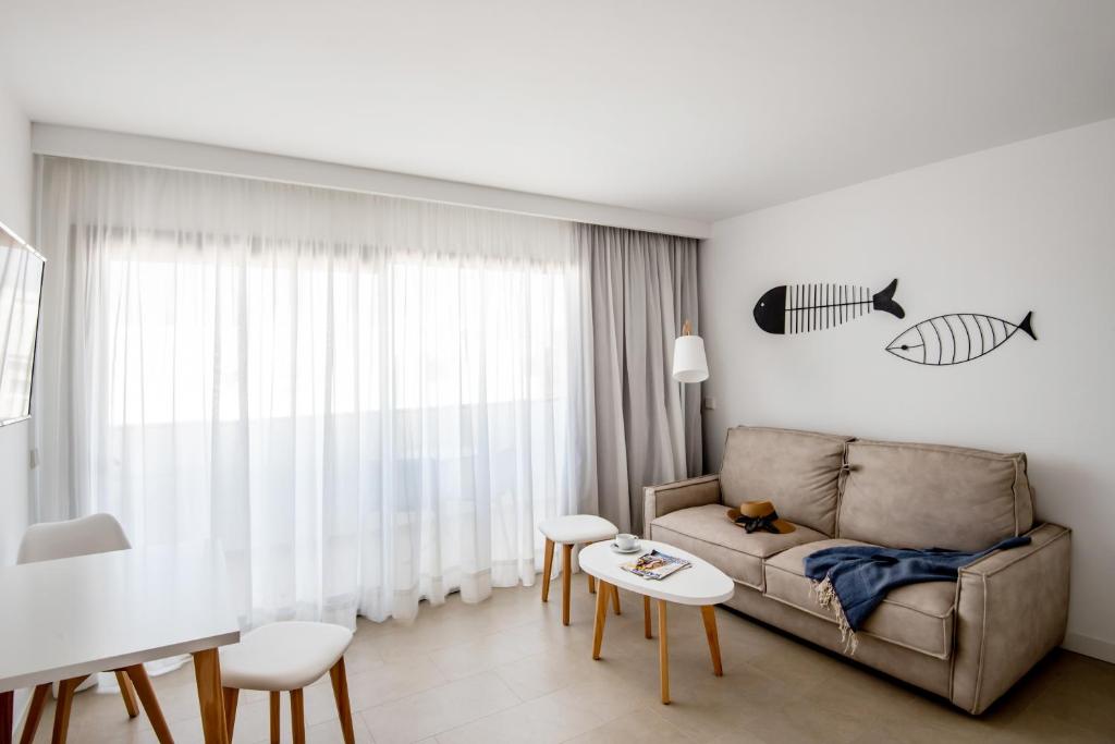 埃斯普霍斯Apartamentos Top Secret Prestige Es Pujols - Formentera Vacaciones的客厅配有沙发和桌子