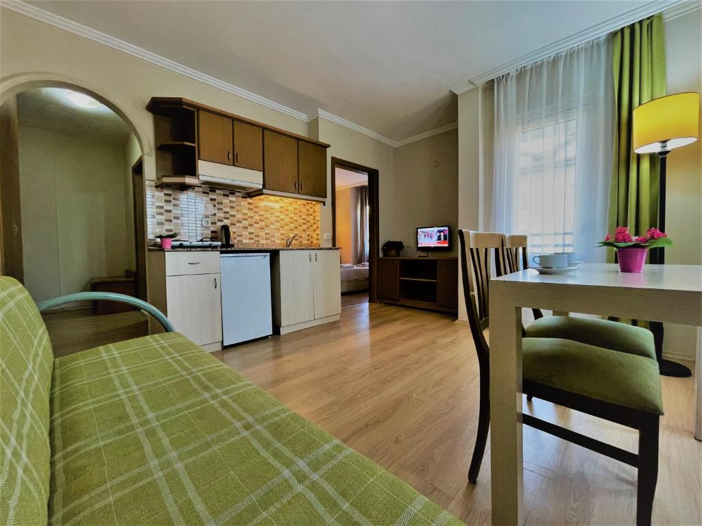 阿拉尼亚Select Suite & Apart Hotel的厨房、带桌子的客厅和用餐室