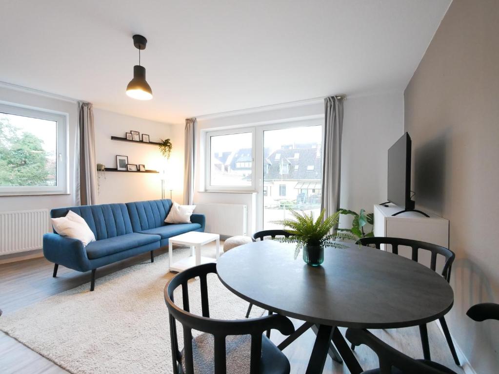 奥斯纳布吕克75 m2, zentral, Küche, Balkon, Parkplatz的客厅配有桌子和蓝色沙发