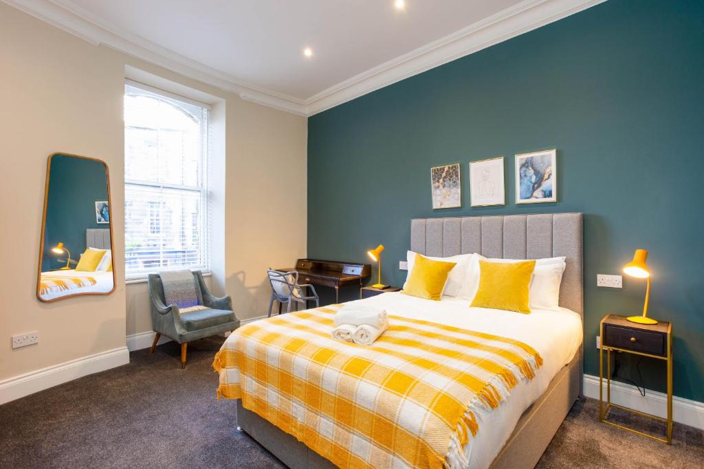 爱丁堡Royal 2bed apartment City Center的一间卧室配有一张床、一张桌子和一把椅子
