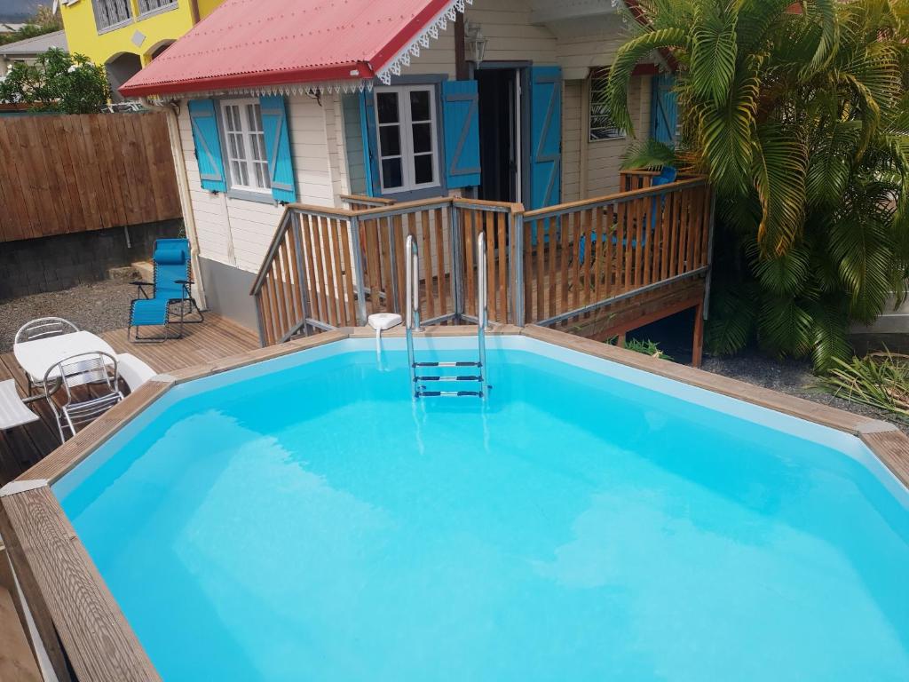 圣路易斯Ti caze des papayes的一座大蓝色游泳池,位于房子前