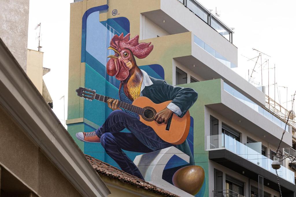 雅典The Rooster's Egg的一座楼房上拿着吉他公鸡的壁画