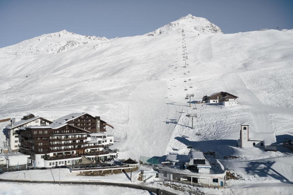 和希格尔TOP Hotel Hochgurgl的雪地中的度假胜地,背景是一座山