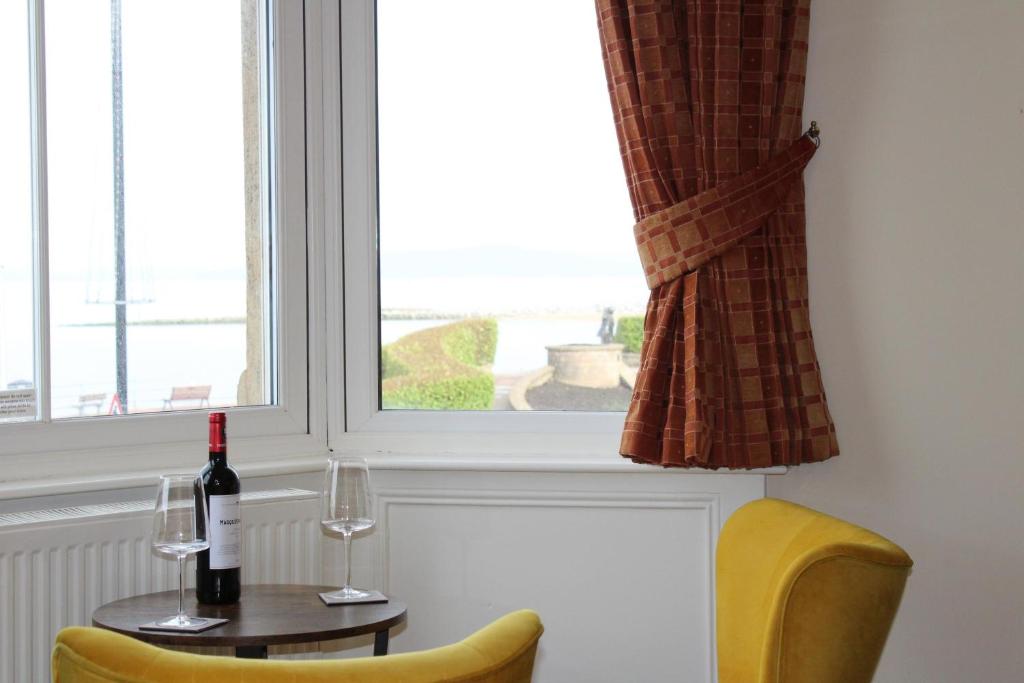 莫克姆皇冠酒店的一张桌子,上面放着一瓶葡萄酒和两杯酒