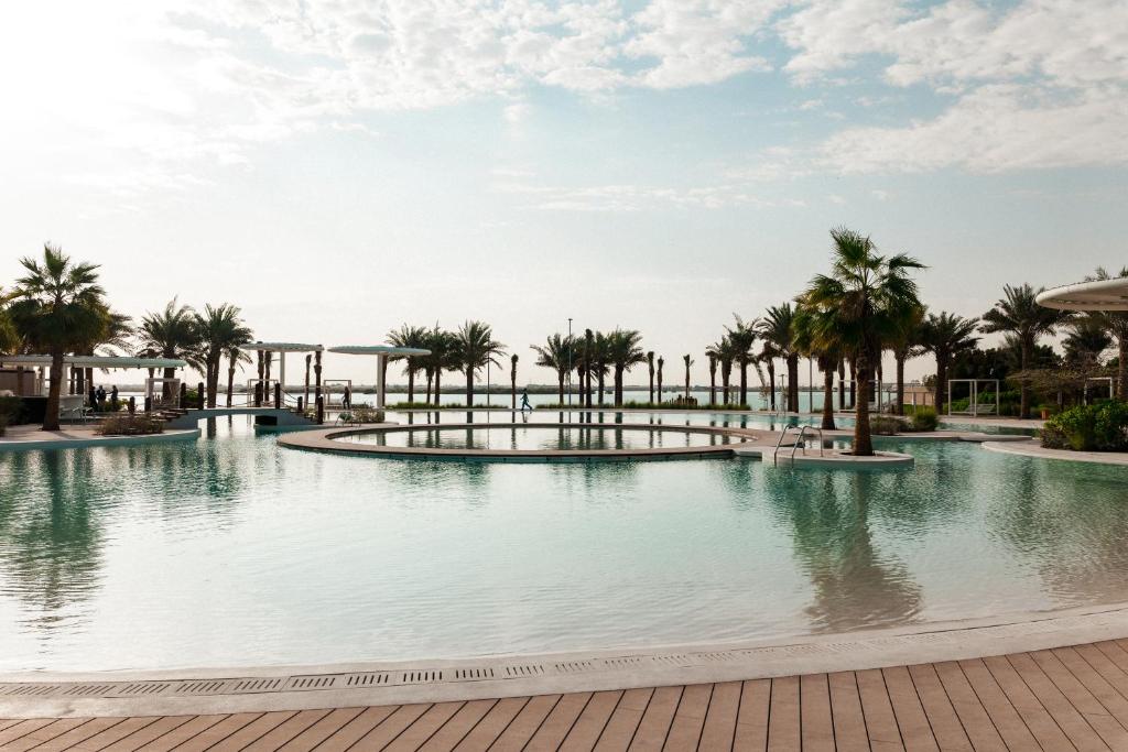 阿布扎比ERTH Abu Dhabi Hotel的度假村内棕榈树游泳池