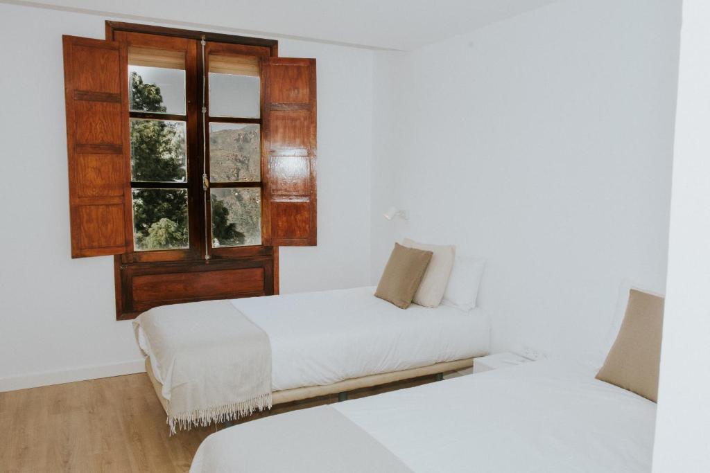 克鲁兹·德·特赫达Texeda Room Suites的一间卧室设有两张床和窗户。