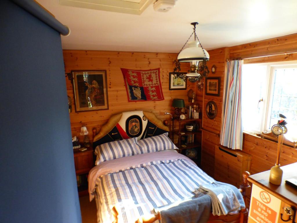 North CreakeNELSONS CABIN的卧室配有一张床铺,位于带木墙的房间内