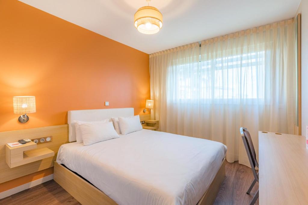 蒙彼利埃蒙彼利埃欧弗利I号城市舒适公寓式酒店的卧室配有白色的床和窗户。