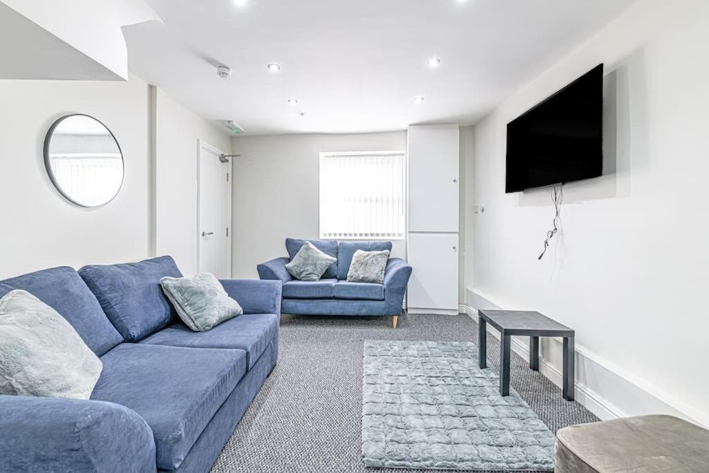 普雷斯科特Luxury 5 Bedroom Holiday Home Within Prescot的客厅配有蓝色的沙发和电视