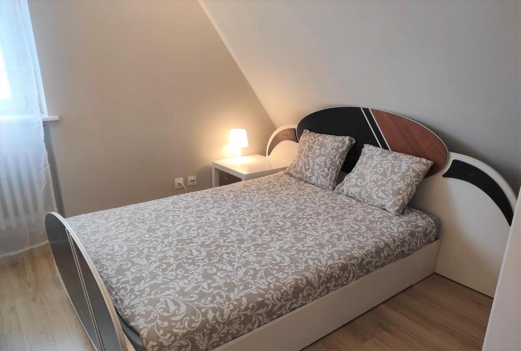 波兹南Rynek 11的一间小卧室,配有一张带木制床头板的床