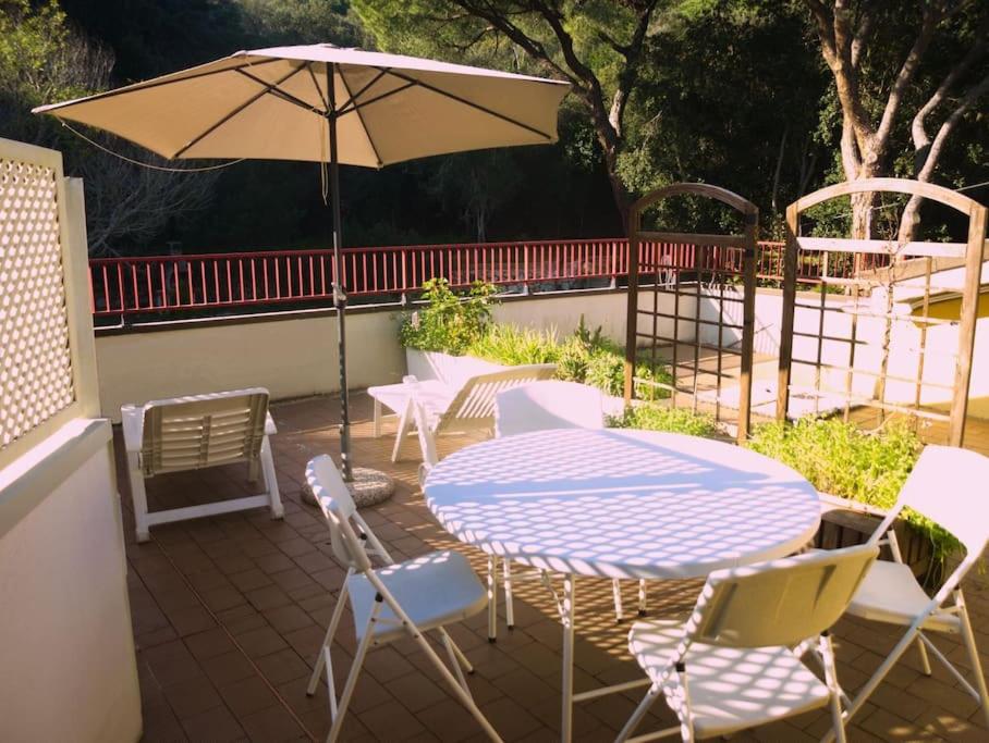 卡沃Attico cavo a pochi passi dal mare的庭院配有桌椅和遮阳伞。