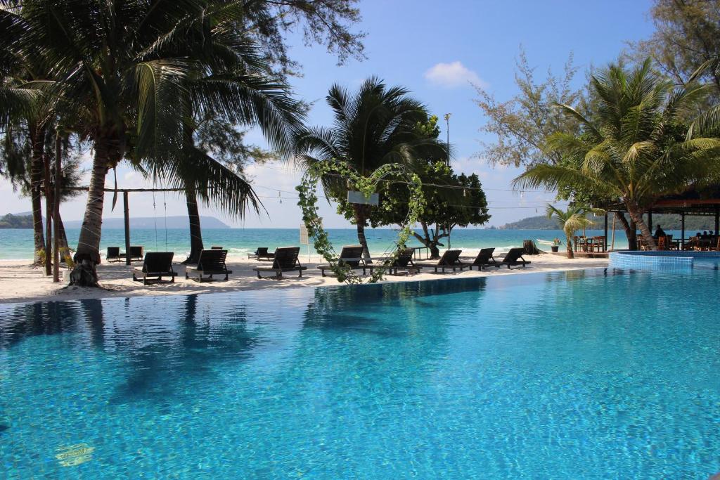 瓜隆岛SCARLET SAILS BUNGALOW的棕榈树海滩旁的游泳池