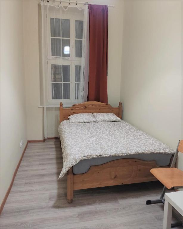 波兹南Rynek 7的一间卧室设有一张木床和一个窗户。