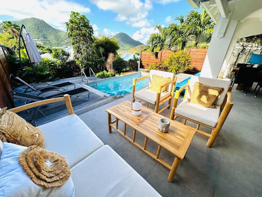 Cul de SacVilla Essentielle, cozy vacation home 3 bedrooms and pool!的一个带桌椅的庭院和一个游泳池