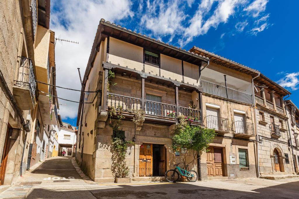 托尔纳瓦卡斯Antigua Posada, Valle del Jerte的一座古老的建筑,前面有一辆自行车停放