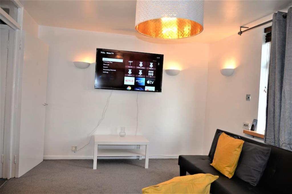 伦敦London Zone 2, 2 Bedroom House的客厅配有沙发和墙上的电视