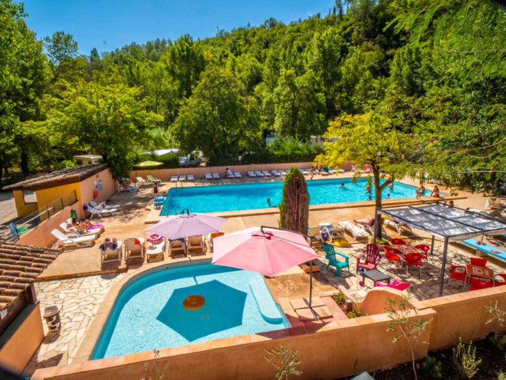 卢河畔图尔雷泰Camping Hotel Les Rives du Loup的享有带椅子和遮阳伞的游泳池的上方景色