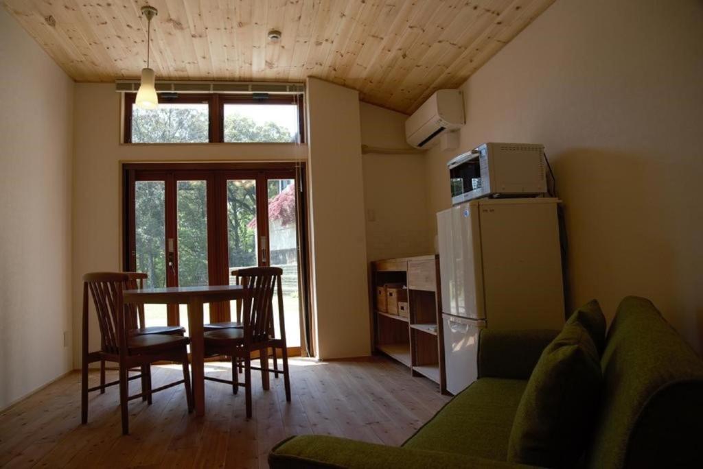 奈良鹿苑山庄山林小屋的客厅配有桌椅和冰箱。
