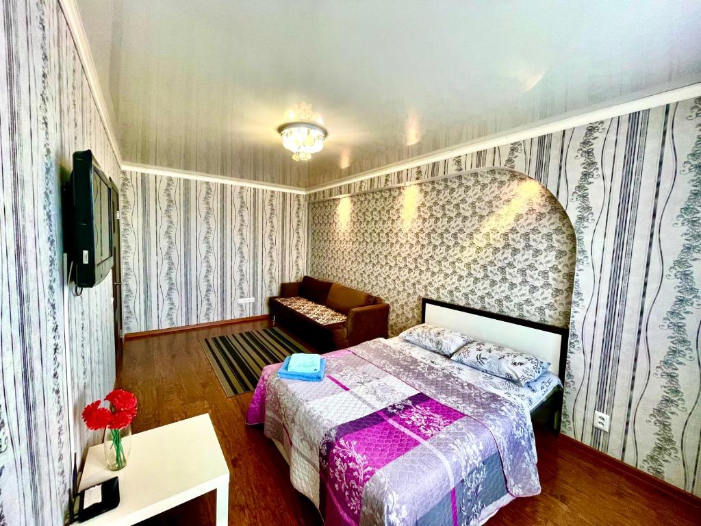 巴甫洛达尔Apartments on Kuban 63的一间卧室配有一张床和一张沙发
