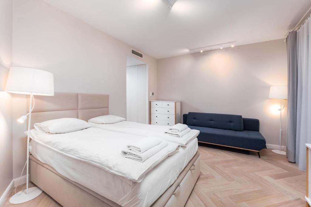 华沙Apartament Solidarności by Your Freedom的一间卧室配有一张床和一张蓝色的沙发