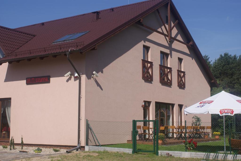 OsowiecU Hołosia的一间白色的大房子,有棕色的屋顶