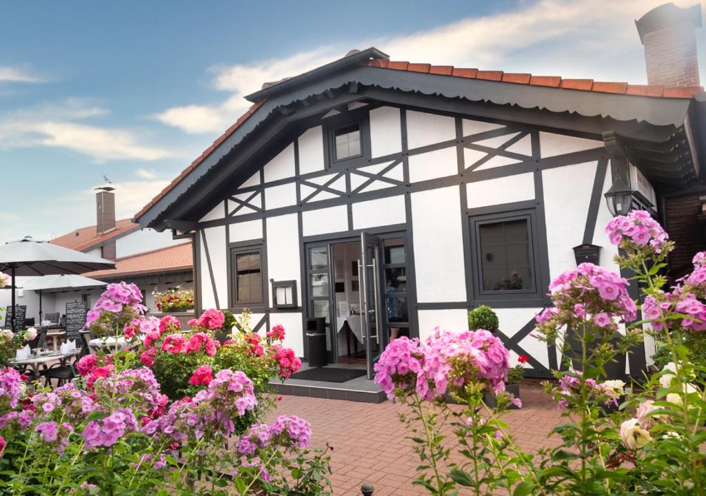 拉姆斯泰因-米森巴赫Hotel Rosenhof GmbH的前面有粉红色花的房子