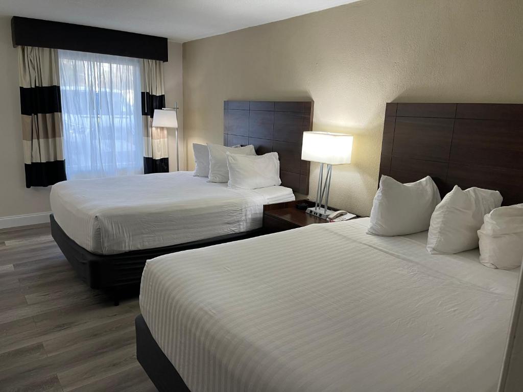 萨拉索塔All-New, Ground-Floor, Huge Pool, Tiki Bar & Grill的酒店客房设有两张床和窗户。