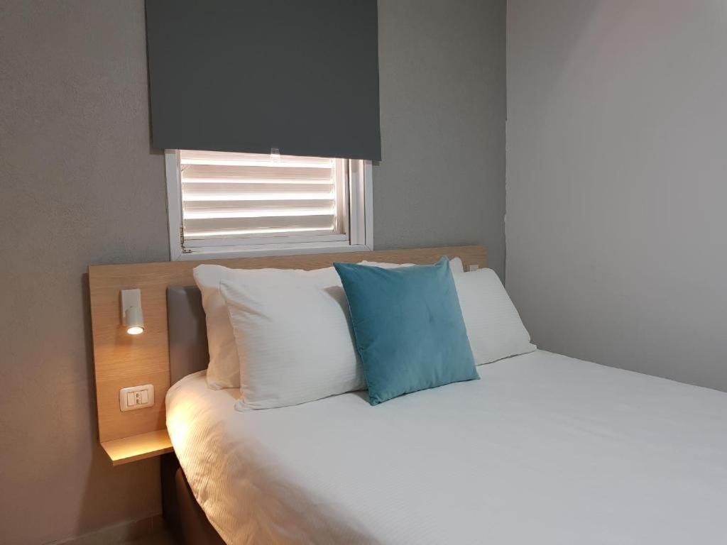 Or YehudaAirport Guest House的床上有蓝色枕头