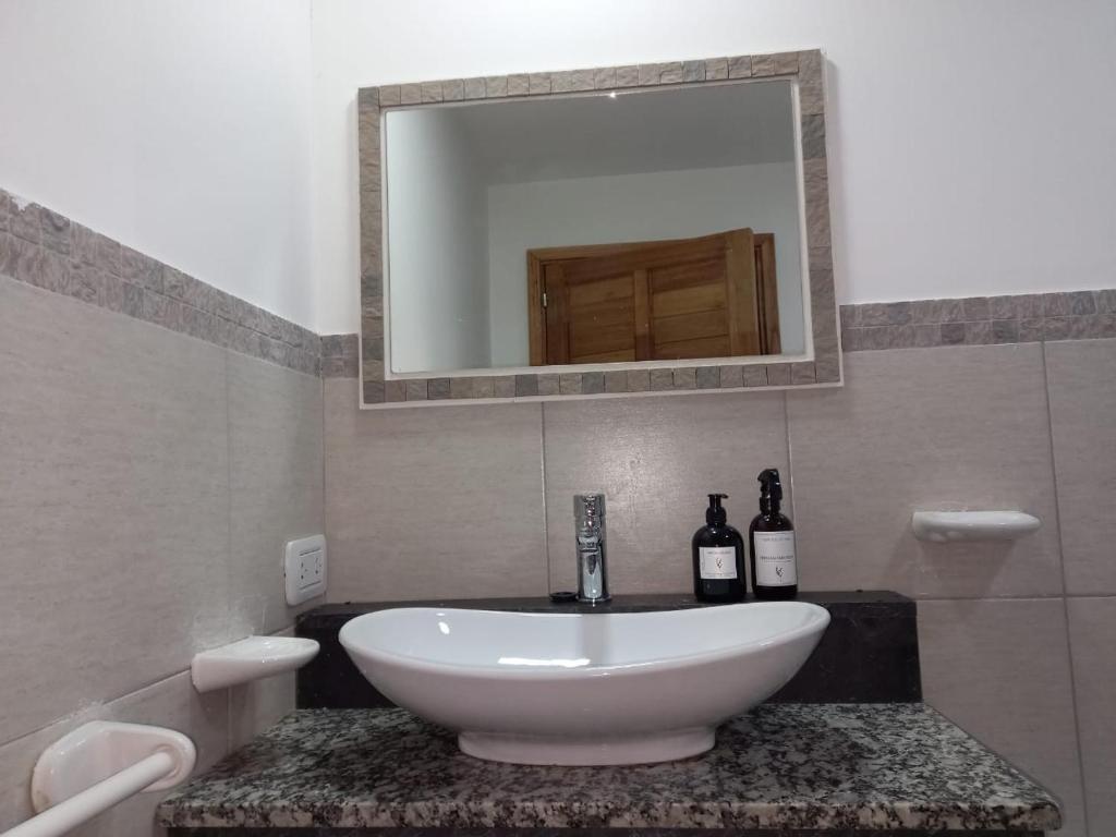埃斯克尔Casa Nera的一间带水槽和两瓶葡萄酒的浴室