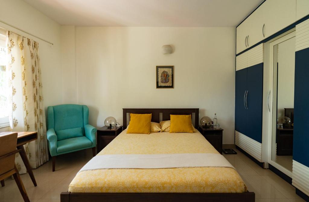 班加罗尔Luho 206的一间卧室配有一张床和一张蓝色椅子